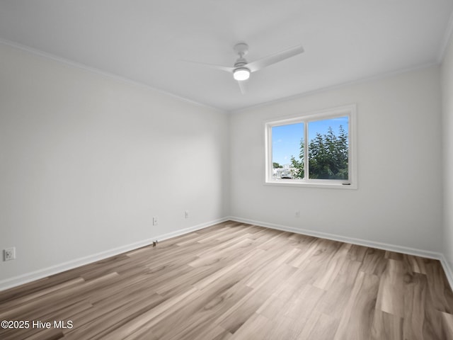 empty room featuring ceiling fan, crown molding, light wood-type flooring, and baseboards