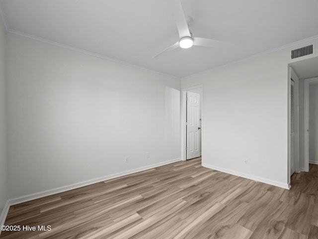 empty room featuring wood finished floors, a ceiling fan, crown molding, and baseboards