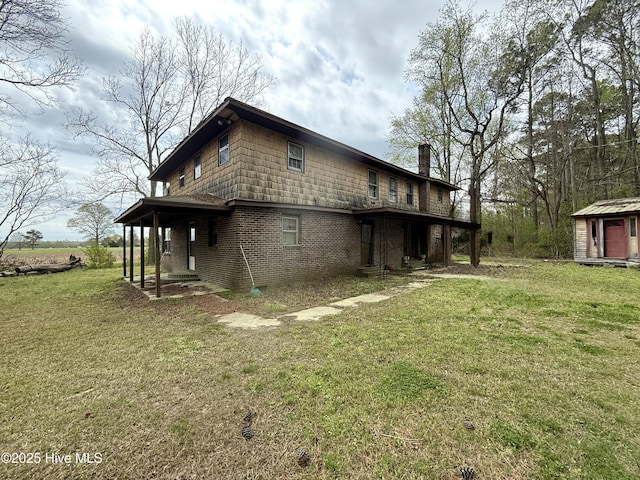 610 S Main St, Roxobel, NC 27872 - view of property exterior with an outdoor structure, brick siding, a yard, and a chimney