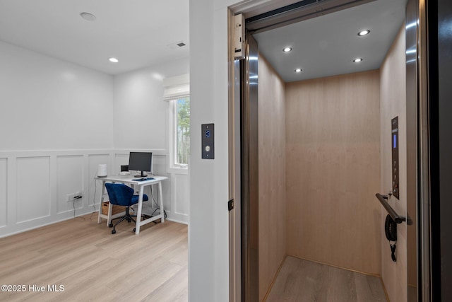 546 S Brightleaf Dr, Minnesott Beach, NC 28510 - office area featuring a wainscoted wall, wood finished floors, elevator, a decorative wall, and recessed lighting