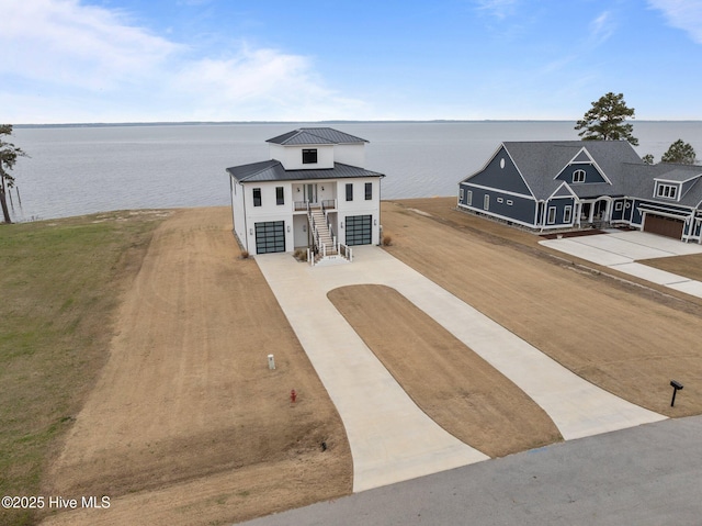 546 S Brightleaf Dr, Minnesott Beach, NC 28510 - view of front of home featuring concrete driveway, a water view, stairway, and metal roof