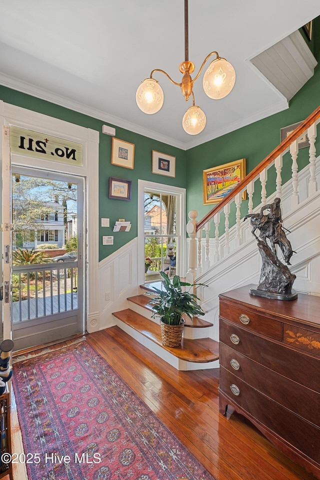 211 S 2nd St, Wilmington, NC 28401 - foyer entrance featuring stairway, hardwood / wood-style flooring, a chandelier, crown molding, and a wainscoted wall