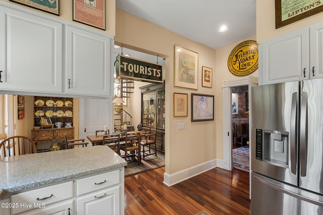 211 S 2nd St, Wilmington, NC 28401 - kitchen featuring stainless steel fridge, baseboards, dark wood-type flooring, white cabinets, and light stone counters