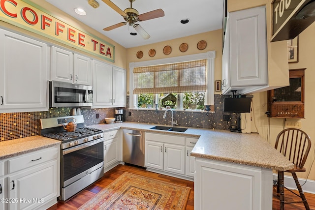 211 S 2nd St, Wilmington, NC 28401 - kitchen with stainless steel appliances, a sink, a ceiling fan, white cabinets, and recessed lighting