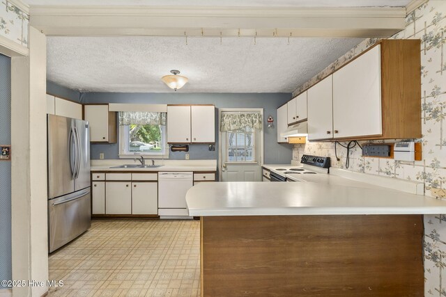 2109 Arendell St, Morehead City, NC 28557 - kitchen with freestanding refrigerator, white dishwasher, electric range oven, a sink, and wallpapered walls