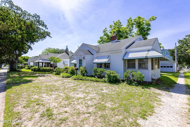 2109 Arendell St, Morehead City, NC 28557 - view of front of home featuring a garage, roof with shingles, and a chimney