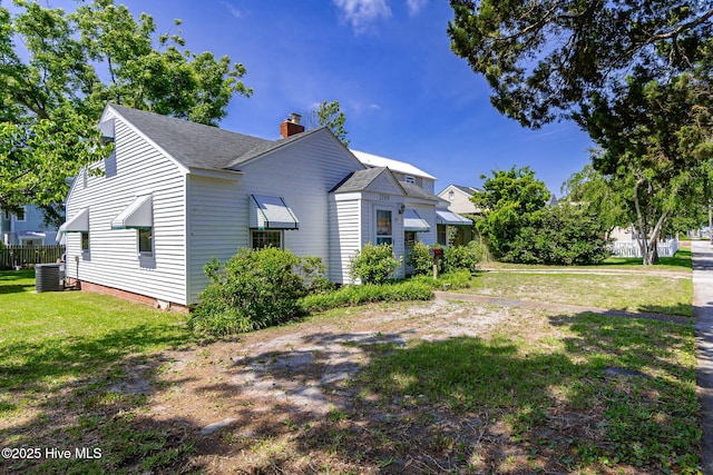2109 Arendell St, Morehead City, NC 28557 - view of side of home featuring a chimney, a yard, a shingled roof, and central AC
