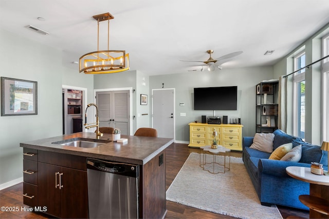 kitchen with stainless steel dishwasher, a sink, dark wood finished floors, baseboards, and visible vents