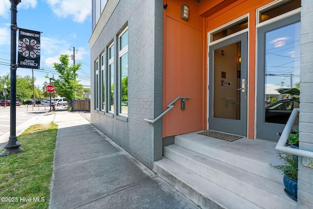 doorway to property with brick siding