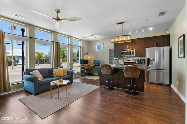 living area featuring ceiling fan, baseboards, visible vents, and dark wood-style floors