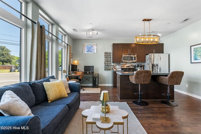 living area featuring visible vents, baseboards, and dark wood-style floors