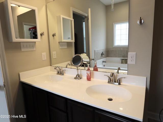full bath with a bath, a sink, and double vanity