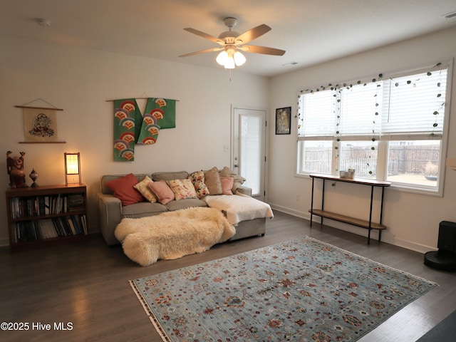 living room featuring ceiling fan, baseboards, wood finished floors, and visible vents
