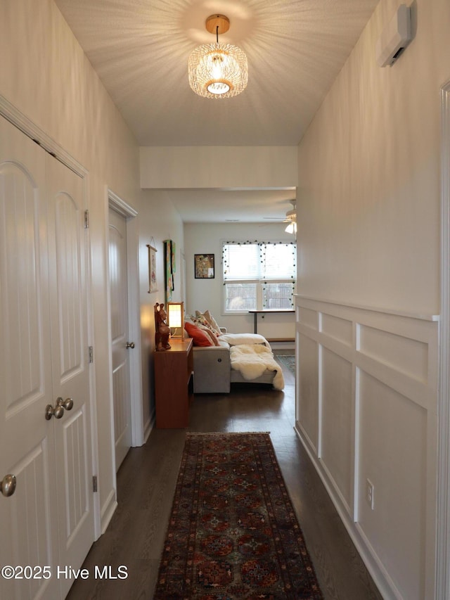 hallway featuring dark wood-style floors and a chandelier