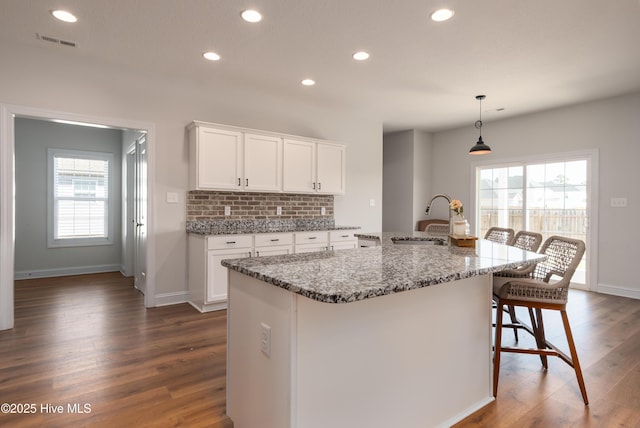 kitchen with white cabinets, recessed lighting, visible vents, a sink, and dark wood-type flooring