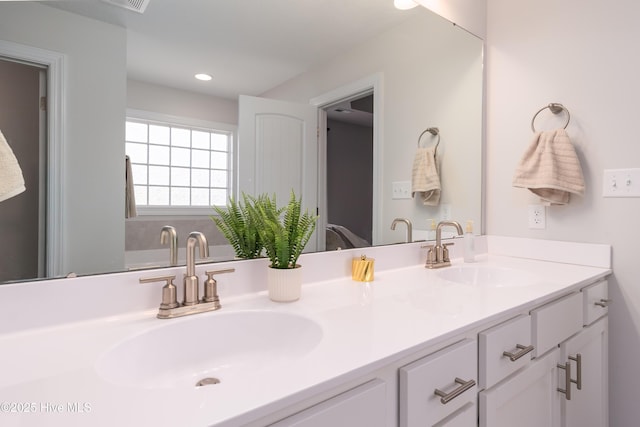 full bath featuring visible vents, a sink, recessed lighting, and double vanity