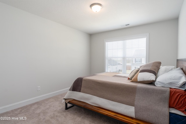 bedroom featuring baseboards, visible vents, and carpet flooring