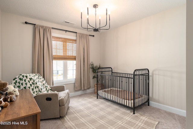 carpeted bedroom with a nursery area, visible vents, baseboards, and an inviting chandelier