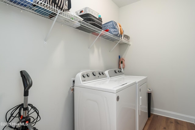 laundry area featuring baseboards, wood finished floors, washer and dryer, and laundry area