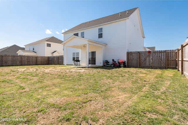 back of house with a fenced backyard, a gate, ceiling fan, a yard, and a patio