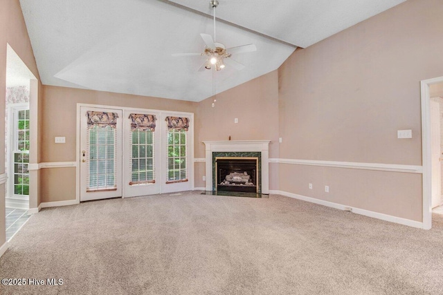 unfurnished living room featuring carpet flooring, ceiling fan, baseboards, a fireplace, and high vaulted ceiling