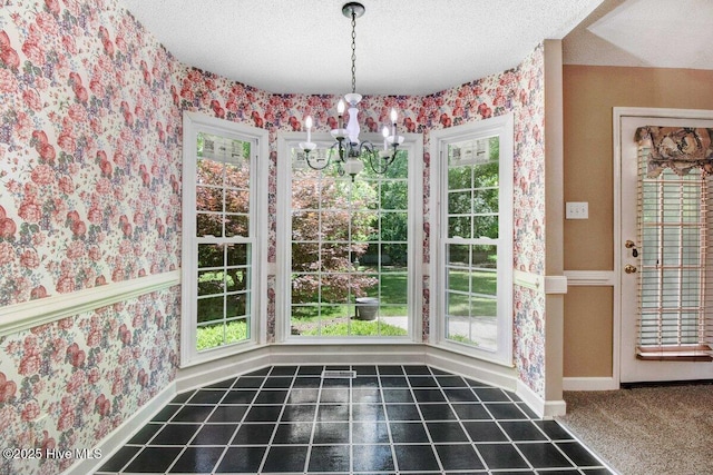 unfurnished dining area with wallpapered walls, a chandelier, baseboards, healthy amount of natural light, and a textured ceiling