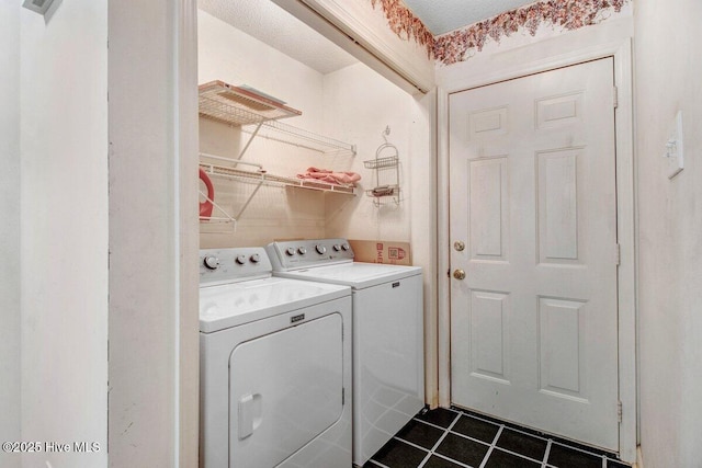 laundry room with washer and dryer and dark tile patterned flooring