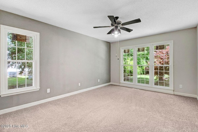 carpeted spare room with baseboards, a textured ceiling, and ceiling fan