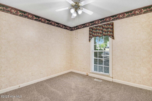 unfurnished room with carpet flooring, baseboards, ceiling fan, and a textured ceiling