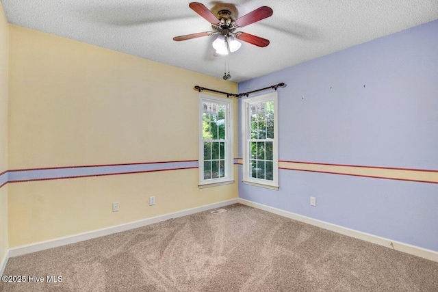 empty room featuring carpet floors, ceiling fan, baseboards, and a textured ceiling