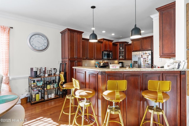 kitchen with glass insert cabinets, a peninsula, dark brown cabinets, appliances with stainless steel finishes, and wood finished floors