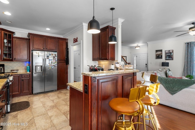 kitchen with ornamental molding, open floor plan, a peninsula, ceiling fan, and stainless steel appliances