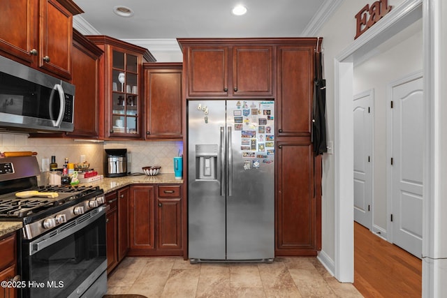 kitchen with glass insert cabinets, ornamental molding, light stone countertops, decorative backsplash, and stainless steel appliances