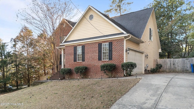 view of front of house featuring a shingled roof, fence, brick siding, an attached garage, and concrete driveway