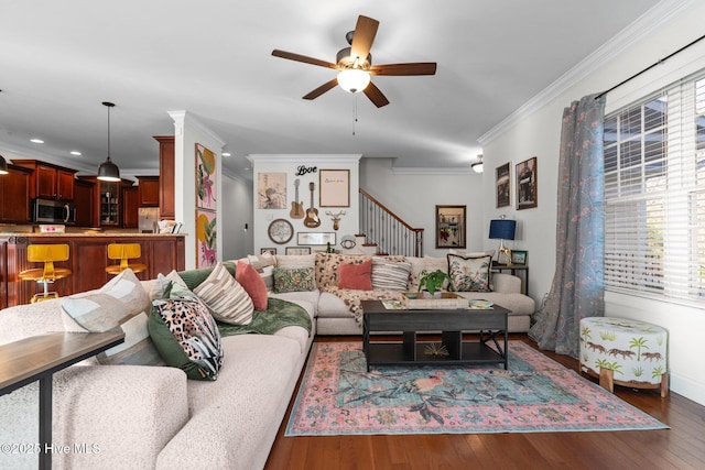 living area featuring hardwood / wood-style floors, ornamental molding, a ceiling fan, and stairway