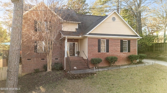 view of front of home with a shingled roof, fence, and brick siding