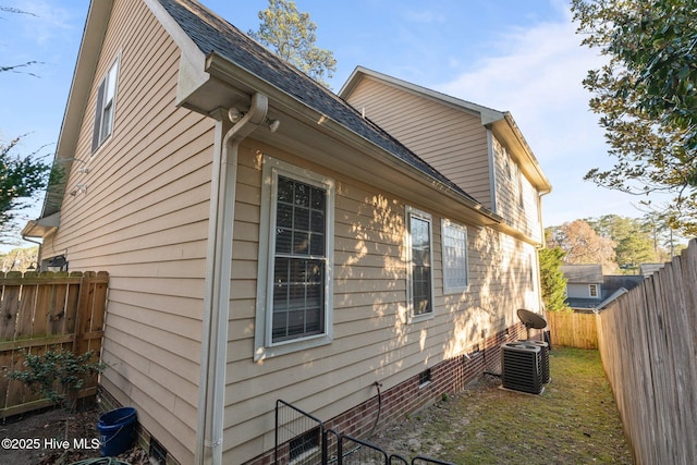 view of property exterior with roof with shingles, a fenced backyard, cooling unit, and crawl space