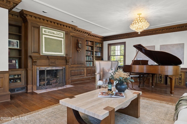 130 Harbour Dr, Hubert, NC 28539 - living area with built in shelves, wood-type flooring, ornamental molding, a fireplace, and a chandelier