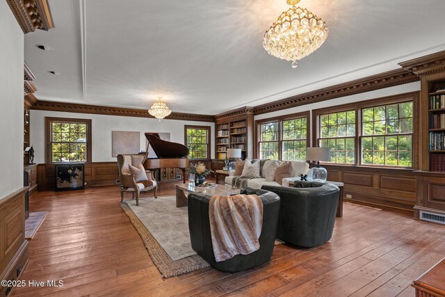 130 Harbour Dr, Hubert, NC 28539 - living area featuring a chandelier, a wainscoted wall, ornamental molding, healthy amount of natural light, and hardwood / wood-style floors