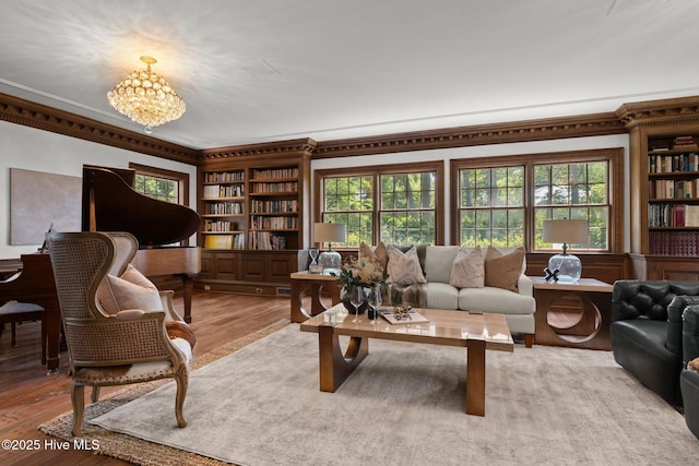 130 Harbour Dr, Hubert, NC 28539 - living room featuring ornamental molding, healthy amount of natural light, a chandelier, light wood-type flooring, and built in features