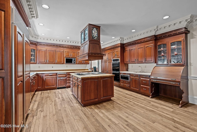 130 Harbour Dr, Hubert, NC 28539 - kitchen featuring light countertops, ornamental molding, light wood finished floors, a kitchen island, and glass insert cabinets