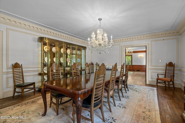 130 Harbour Dr, Hubert, NC 28539 - dining space with ornamental molding, a chandelier, a decorative wall, hardwood / wood-style floors, and a wainscoted wall
