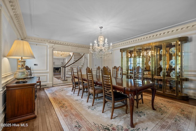 130 Harbour Dr, Hubert, NC 28539 - dining space featuring crown molding, a chandelier, light wood-style flooring, and stairway