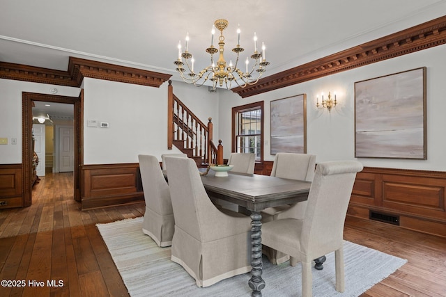 130 Harbour Dr, Hubert, NC 28539 - dining area with a chandelier, wood-type flooring, stairs, a wainscoted wall, and ornamental molding