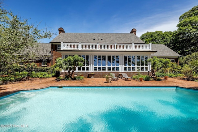130 Harbour Dr, Hubert, NC 28539 - rear view of property featuring a balcony, an outdoor pool, and a chimney