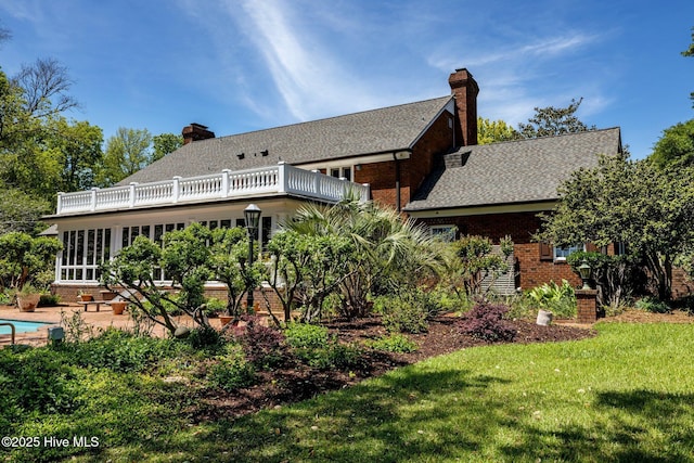 130 Harbour Dr, Hubert, NC 28539 - back of house featuring a balcony, a chimney, a lawn, and brick siding