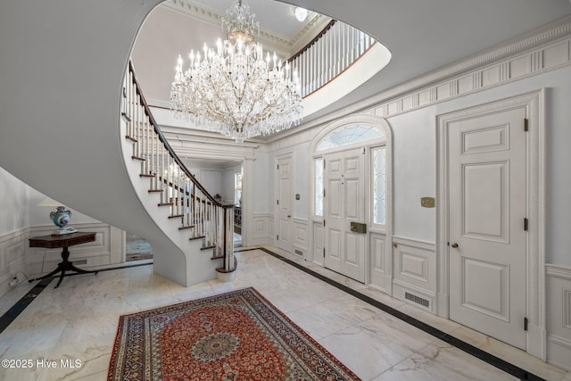 130 Harbour Dr, Hubert, NC 28539 - entrance foyer featuring a decorative wall, inlaid floor details, stairs, a chandelier, and marble tiled flooring