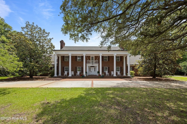 130 Harbour Dr, Hubert, NC 28539 - view of front of house with covered porch, a chimney, a front lawn, and brick siding