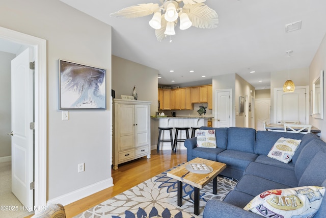 living area with recessed lighting, light wood finished floors, visible vents, a ceiling fan, and baseboards