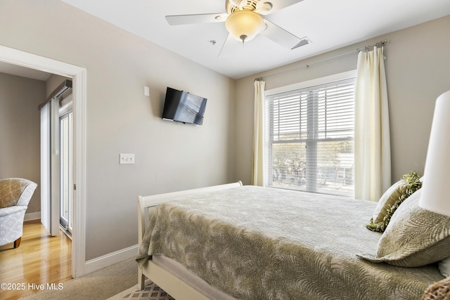 bedroom featuring ceiling fan, baseboards, multiple windows, and visible vents